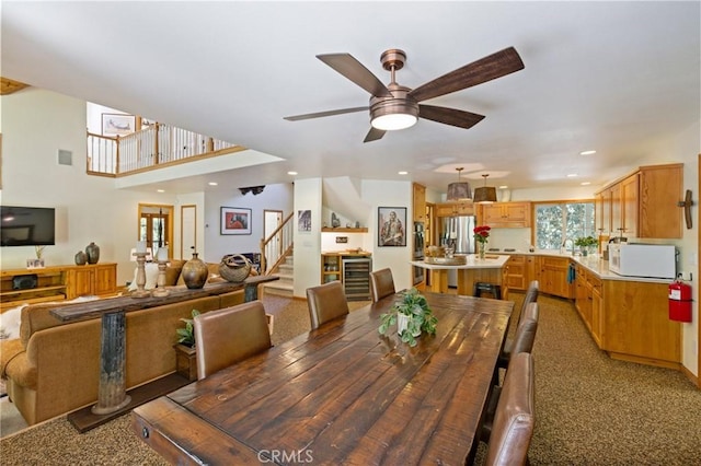 carpeted dining room featuring ceiling fan