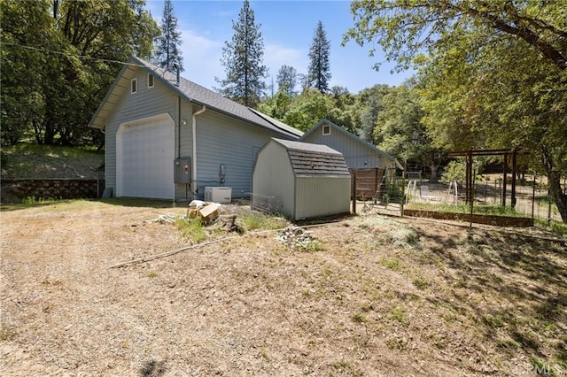 exterior space featuring a garage and a storage unit