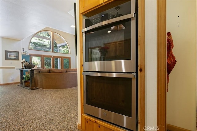 kitchen featuring carpet floors, stainless steel double oven, and light brown cabinets