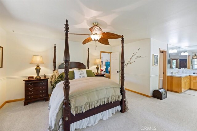 bedroom featuring ceiling fan, connected bathroom, and light carpet