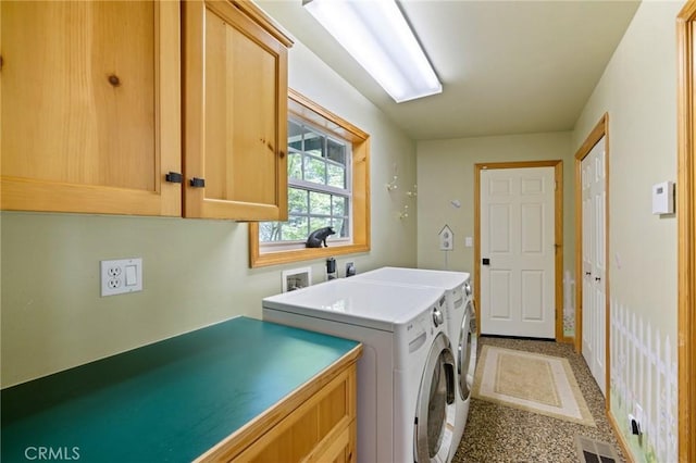 clothes washing area with cabinets and washer and dryer