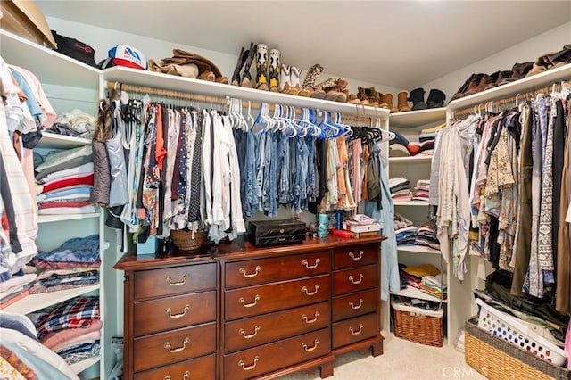 walk in closet featuring light colored carpet