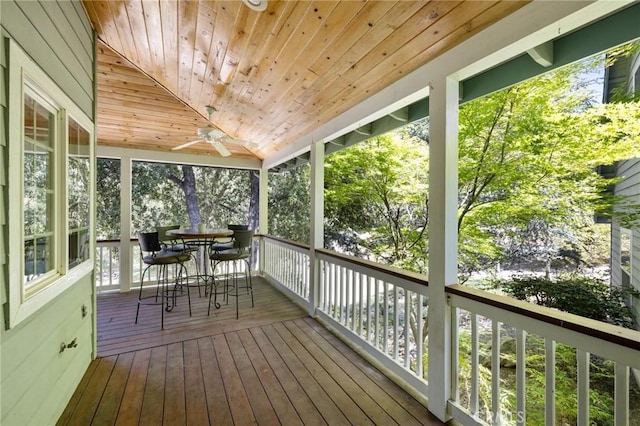 unfurnished sunroom featuring ceiling fan and wood ceiling