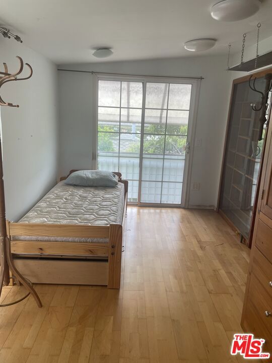 bedroom with access to outside and light hardwood / wood-style flooring