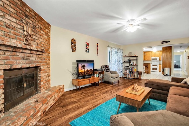 living room featuring a fireplace, ceiling fan, and hardwood / wood-style floors