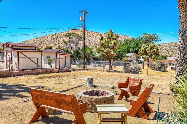 view of yard featuring an outdoor fire pit and a mountain view