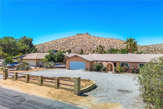 ranch-style home with a garage and a mountain view