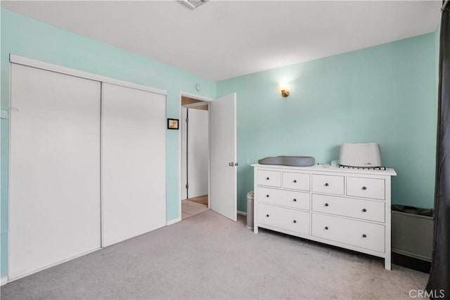 unfurnished bedroom featuring a closet and light carpet