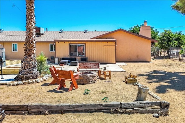 back of property featuring central air condition unit and a fire pit