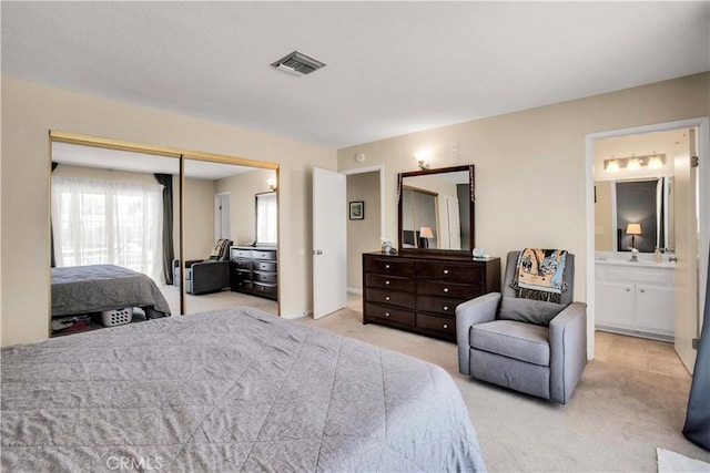 carpeted bedroom with ensuite bath and a closet