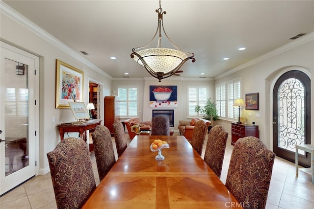 dining room with ornamental molding and light tile floors