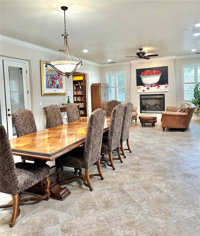 tiled dining room with a healthy amount of sunlight, ceiling fan, and crown molding