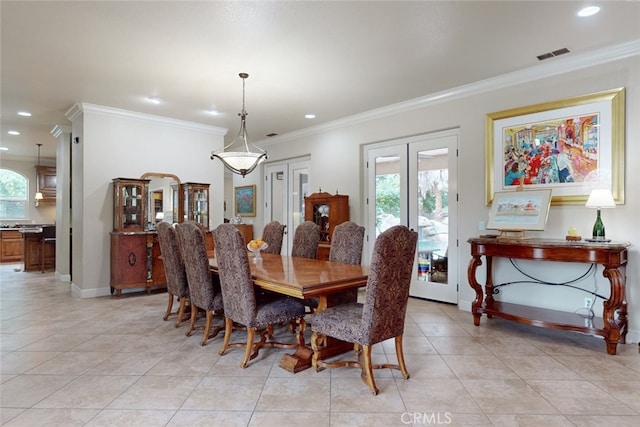 dining room with ornamental molding, light tile flooring, and french doors