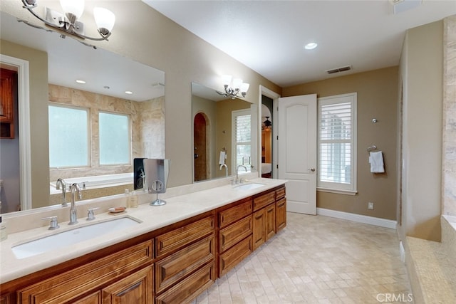 bathroom with double vanity, tile flooring, a notable chandelier, and a washtub