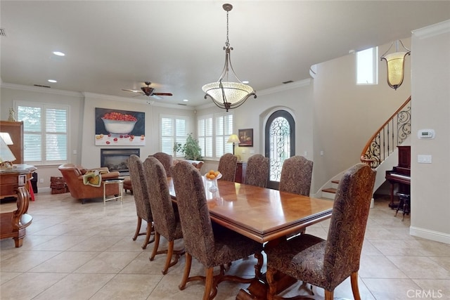 dining area with ornamental molding, ceiling fan, and light tile floors