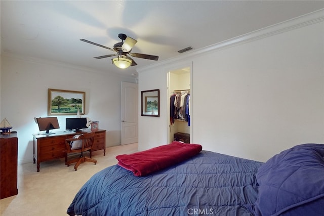 carpeted bedroom with a walk in closet, ornamental molding, a closet, and ceiling fan