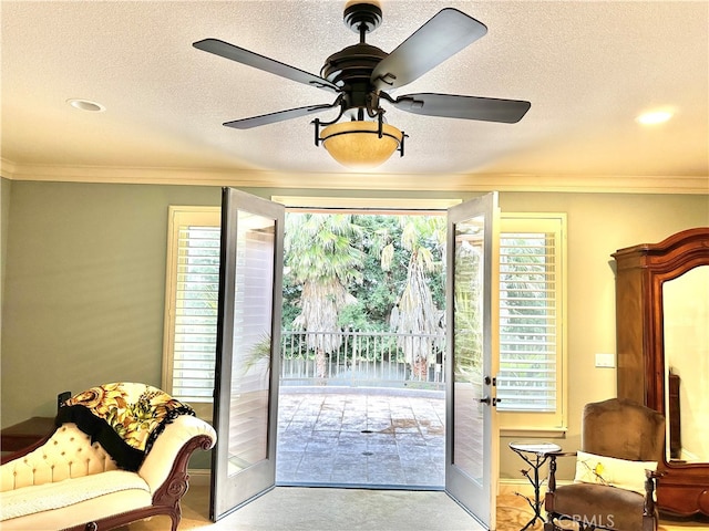 carpeted entryway with plenty of natural light, ornamental molding, and ceiling fan