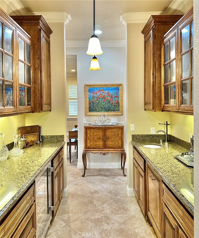 kitchen featuring hanging light fixtures, sink, ornamental molding, and light tile floors