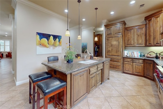 kitchen featuring light stone countertops, light tile flooring, pendant lighting, sink, and a breakfast bar