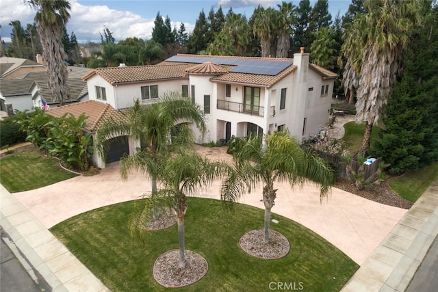 exterior space featuring a front yard, a balcony, and solar panels