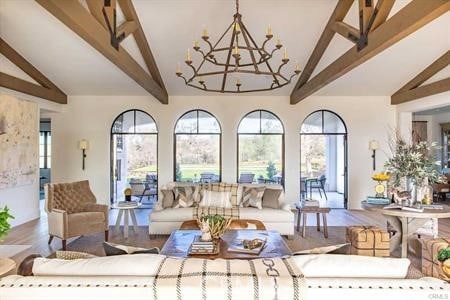 living room with hardwood / wood-style floors, lofted ceiling with beams, and an inviting chandelier