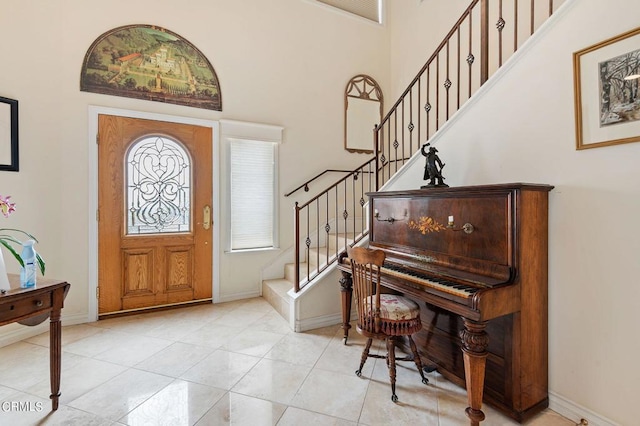 entrance foyer featuring a towering ceiling and light tile patterned floors