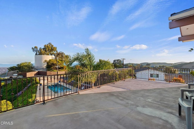 view of patio / terrace featuring a fenced in pool and a mountain view