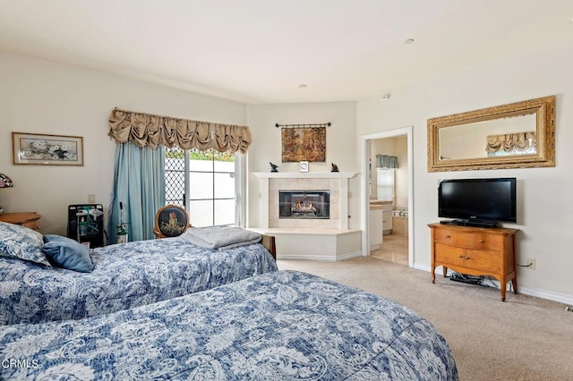 carpeted bedroom with a tiled fireplace and ensuite bathroom