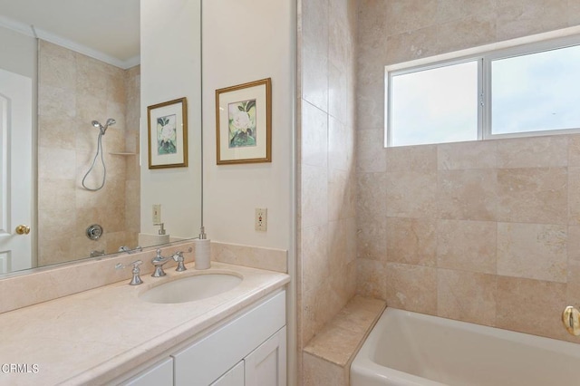 bathroom featuring crown molding, vanity, and tiled shower / bath