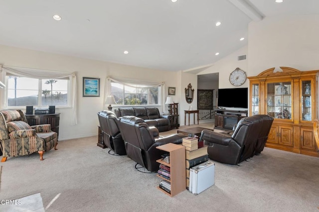 carpeted living room with high vaulted ceiling and beam ceiling