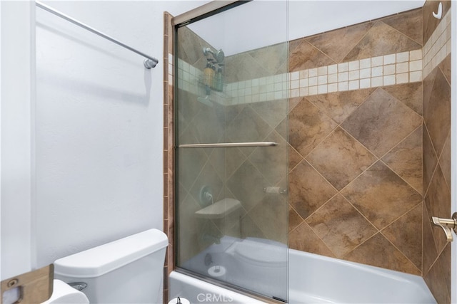 bathroom with bath / shower combo with glass door and toilet