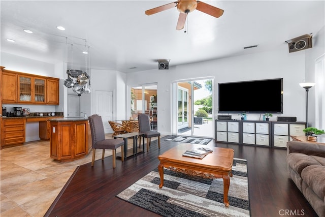 living room featuring light tile flooring and ceiling fan