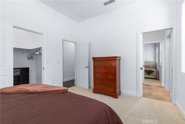 bedroom featuring a spacious closet, light tile flooring, and a closet