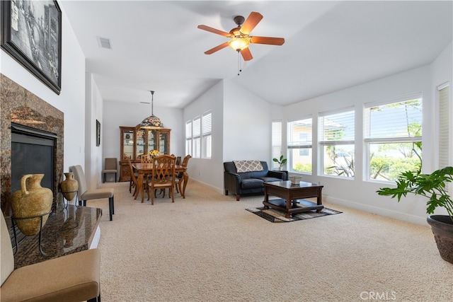 carpeted living room with ceiling fan and vaulted ceiling