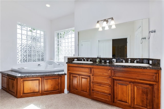 bathroom with vanity with extensive cabinet space, dual sinks, and a bath