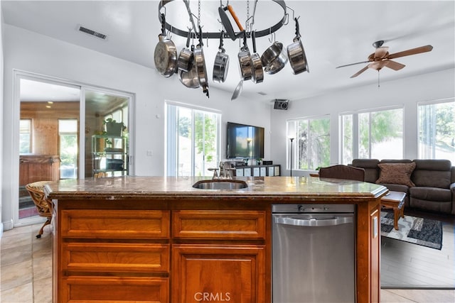 kitchen featuring an island with sink, ceiling fan, dishwasher, and light tile floors