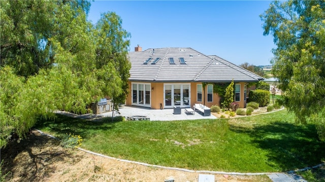 rear view of property with a patio and a lawn