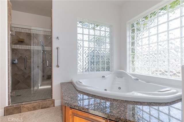 bathroom with plenty of natural light and separate shower and tub