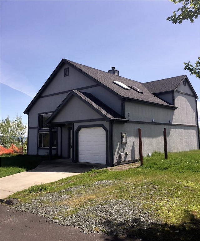 view of front of home with a garage and a front lawn