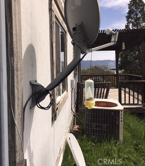 exterior space with central AC unit, a pergola, and a mountain view