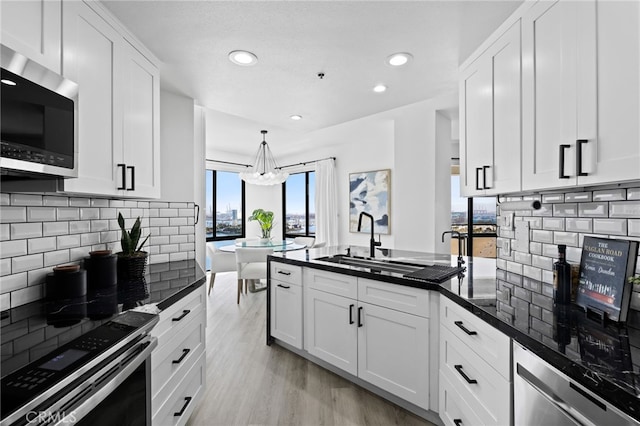 kitchen featuring stainless steel appliances, sink, white cabinets, and light hardwood / wood-style floors