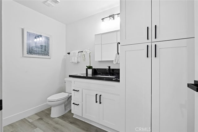 bathroom featuring hardwood / wood-style flooring, vanity, and toilet