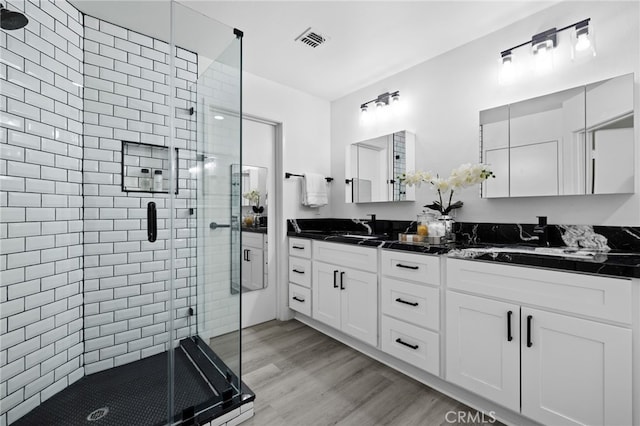 bathroom featuring vanity, a shower with shower door, and hardwood / wood-style floors