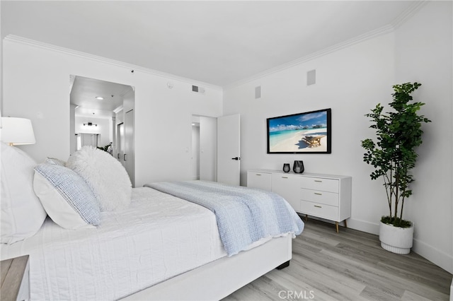 bedroom with light hardwood / wood-style flooring and ornamental molding