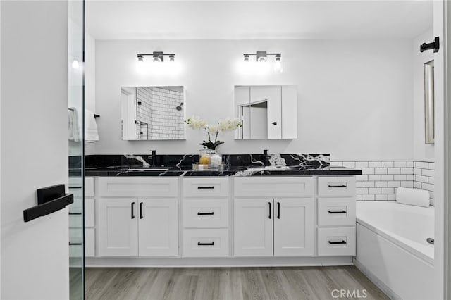 bathroom featuring hardwood / wood-style flooring, vanity, and separate shower and tub