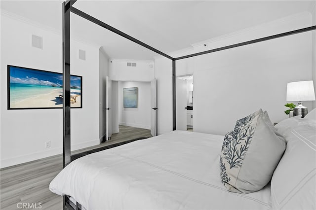 bedroom featuring wood-type flooring and ornamental molding