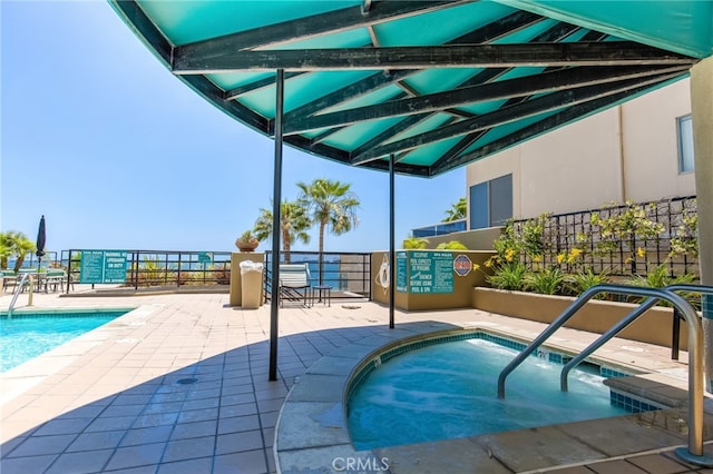 view of swimming pool featuring a patio area and a community hot tub