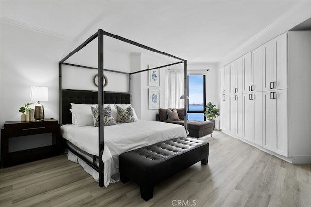 bedroom with crown molding and light wood-type flooring