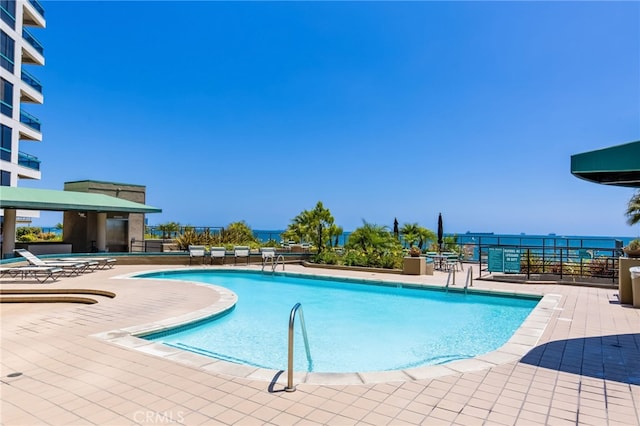 view of swimming pool with a patio and a water view