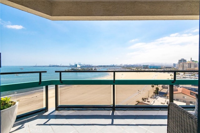 balcony with a water view and a view of the beach